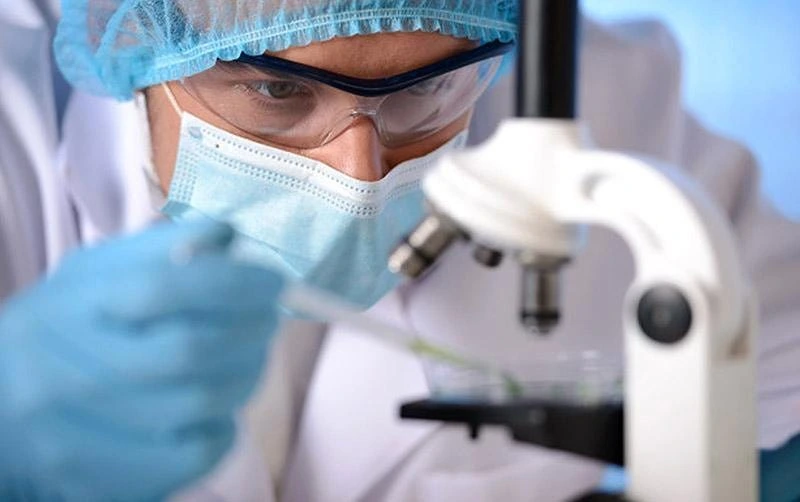 Doctor examining samples under microscope at Aquaporin Aesthetic Hair-Skin Clinix & Labs